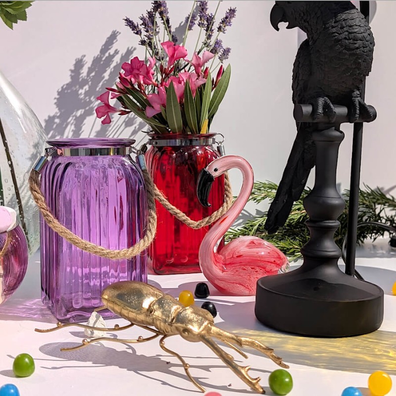 Composition exotique : Décoration d'été mariant le photophore violet à une figurine flamant rose.