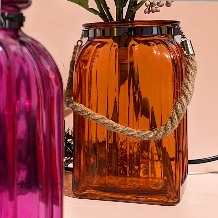 Ambiance bouquet floral : Lanterne orange utilisée comme vase pour accueillir un bouquet de pivoines , devant le modèle fuchsia.