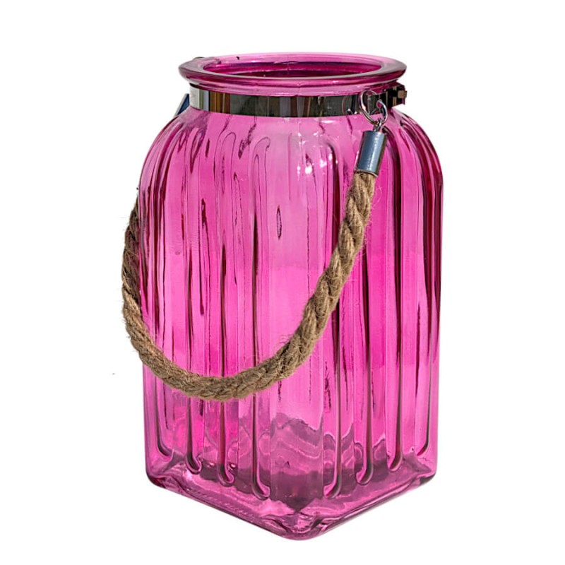 Lanterne photophore en verre teinté rose fuchsia texturé avec son anse en corde sur fond blanc.