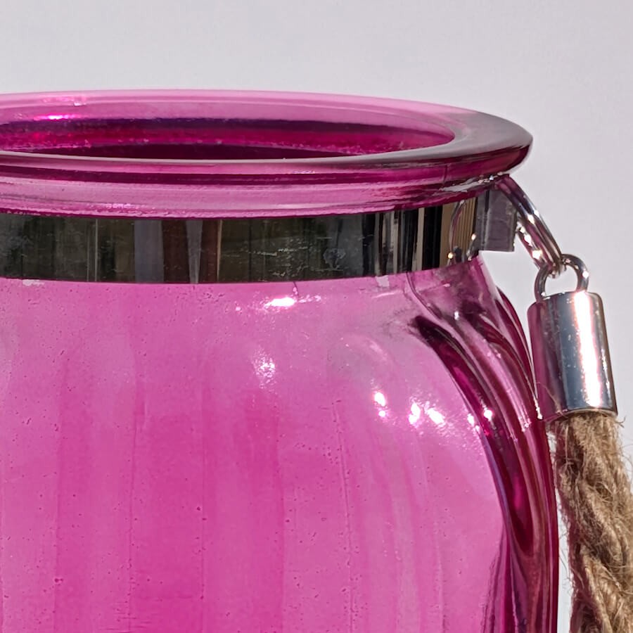 Gros plan col fuchsia : Zoom sur la bague en métal chromé brillant enserrant le goulot de la lanterne rose fuchsia.