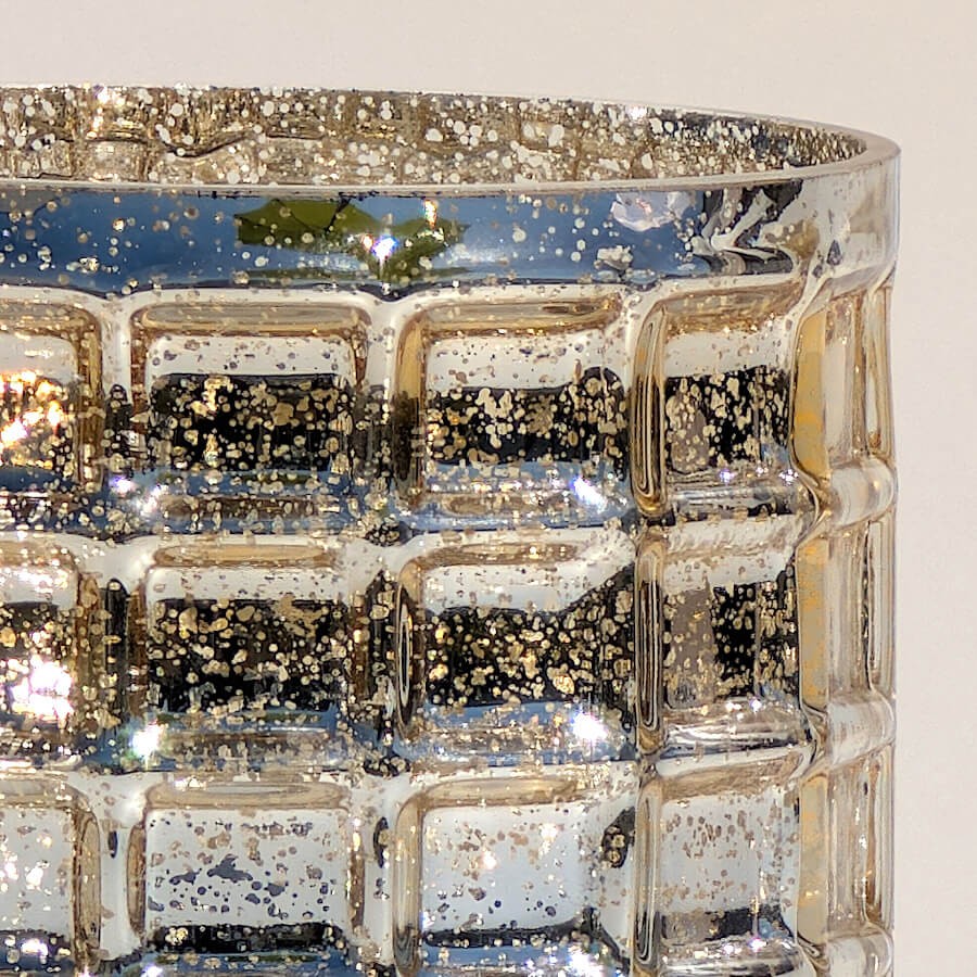 Gros plan sur les motifs géométriques en relief et le fini texturé du photophore en verre gaufré.
