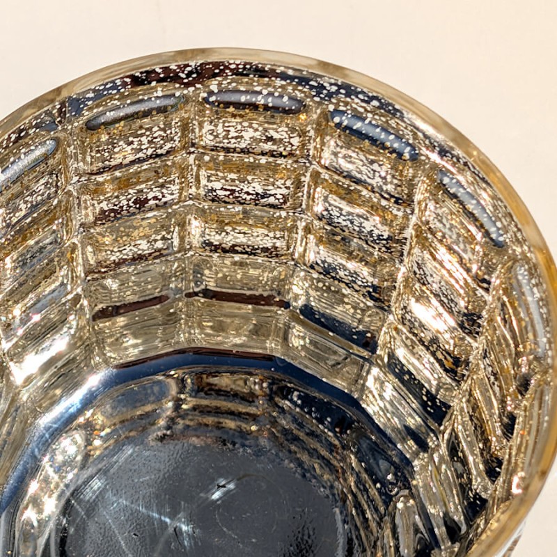 Vue du dessus plongeante révélant l'intérieur argenté moucheté et la transparence du photophore gaufré.