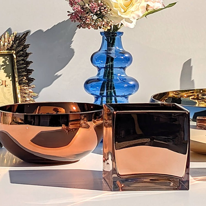Duo esthétique présentant le bol en verre cuivré et le photophore cuivré sous une lumière rasante.