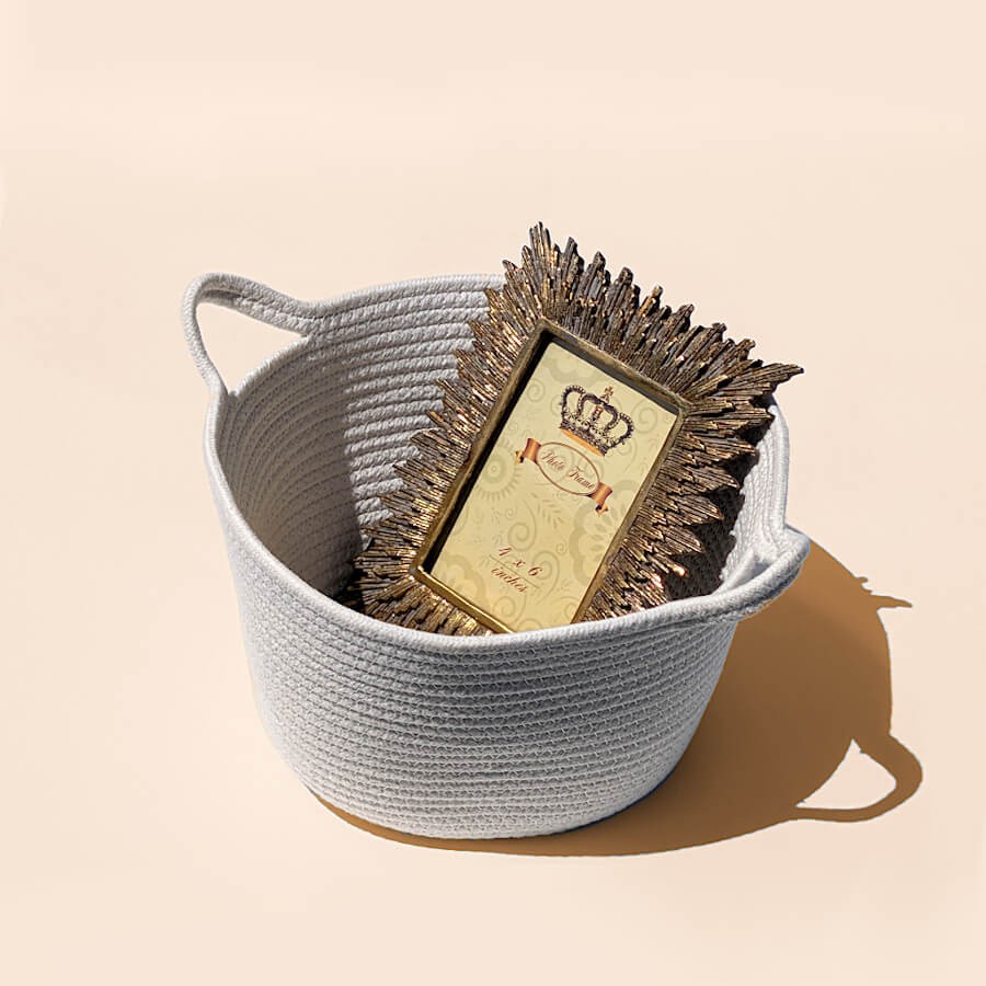 Rangement déco : Le panier blanc accueillant un cadre photo doré texturé pour une idée cadeau charmante.