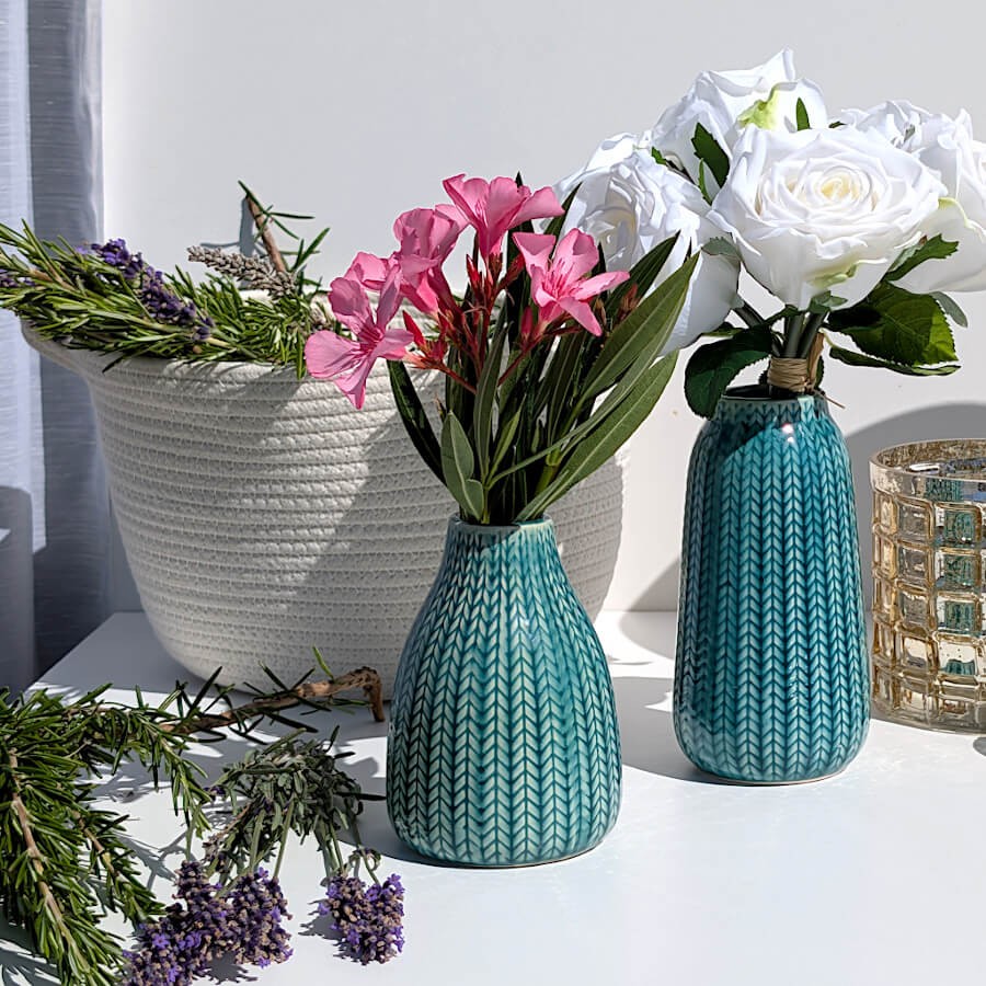 Harmonie florale : Composition bucolique associant le panier en corde blanche à des vases bleus et turquoise garnis de fleurs.