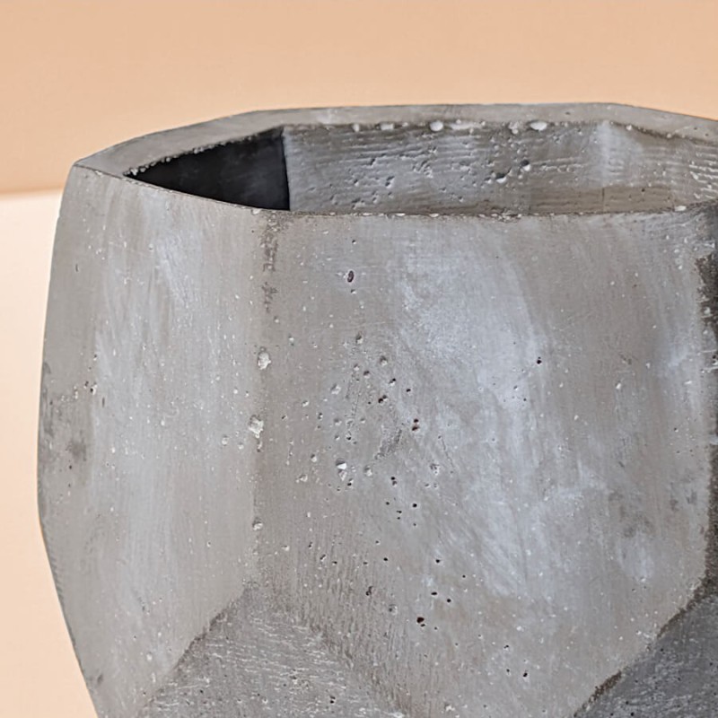 Zoom sur la texture brute, granuleuse et authentique de la paroi en ciment gris clair.