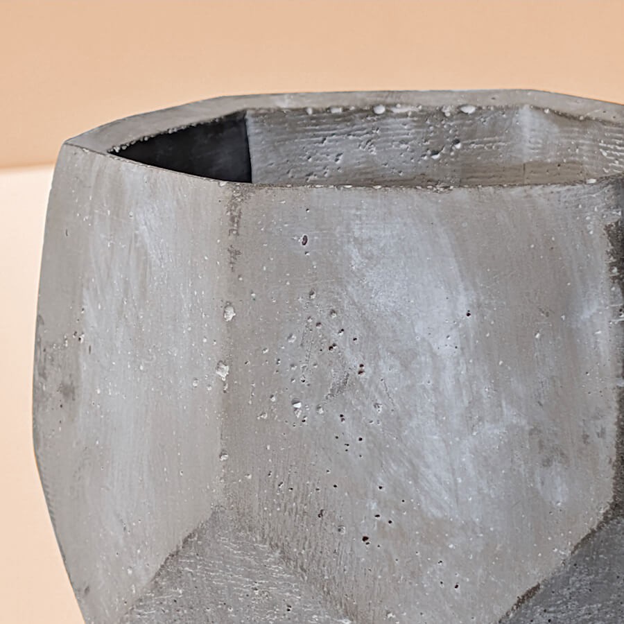 Zoom sur la texture brute, granuleuse et authentique de la paroi en ciment gris clair.