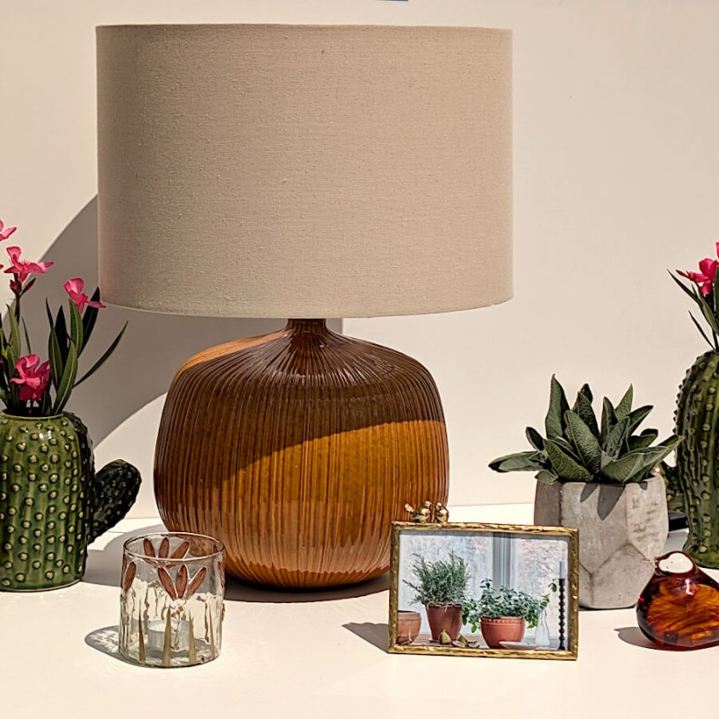 Décoration d'intérieur épurée associant un cache-pot cactus vert, la lampe ocre et le petit pot géométrique facetté.