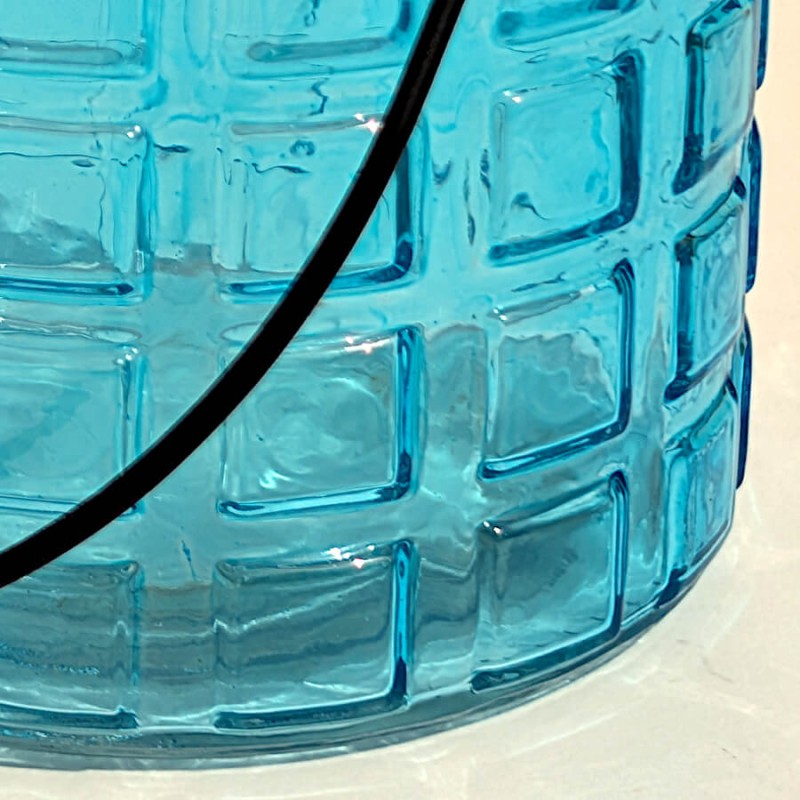 Zoom sur les reliefs rectangulaires et la transparence du verre aqua.