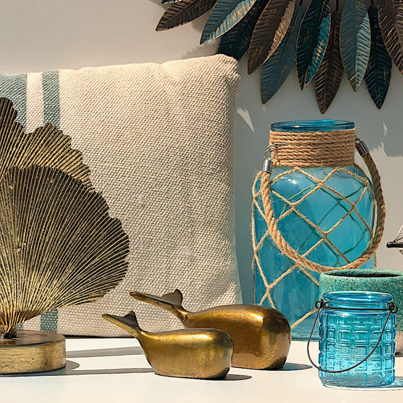 Ambiance marine avec coussin rayé, baleine dorée et photophore bleu aqua Deco-Delight.