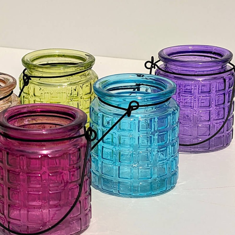 Harmonie de couleurs vives avec photophores fuchsia, turquoise et violet.