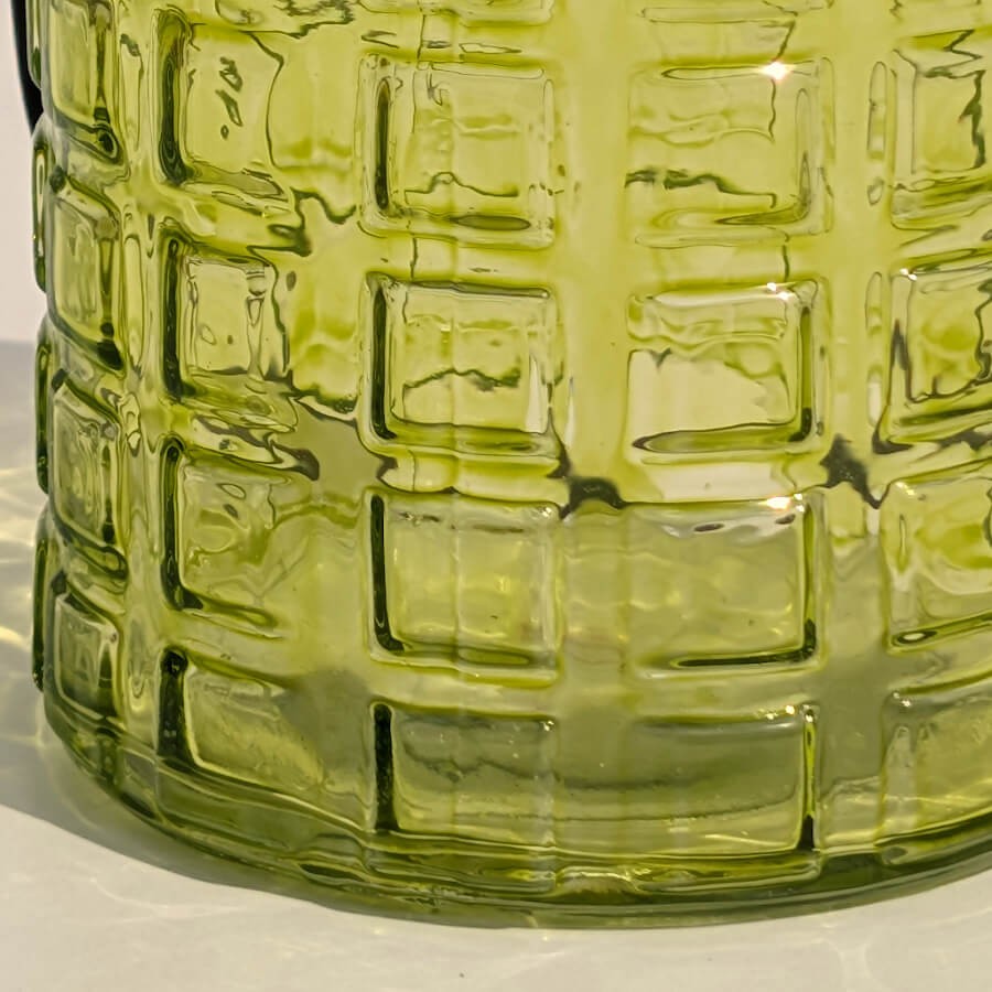 Détail de la surface gaufrée en relief du verre teinté vert.