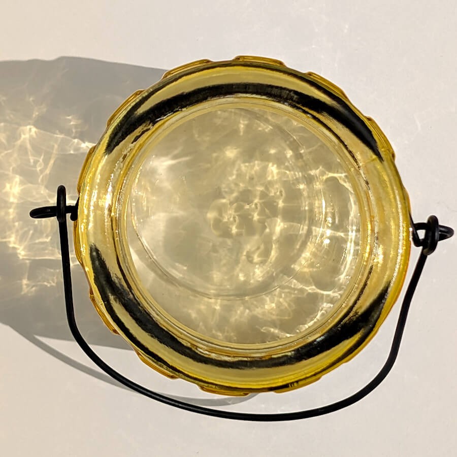 Vue du dessus d'un photophore jaune montrant l'emplacement pour bougie chauffe-plat.