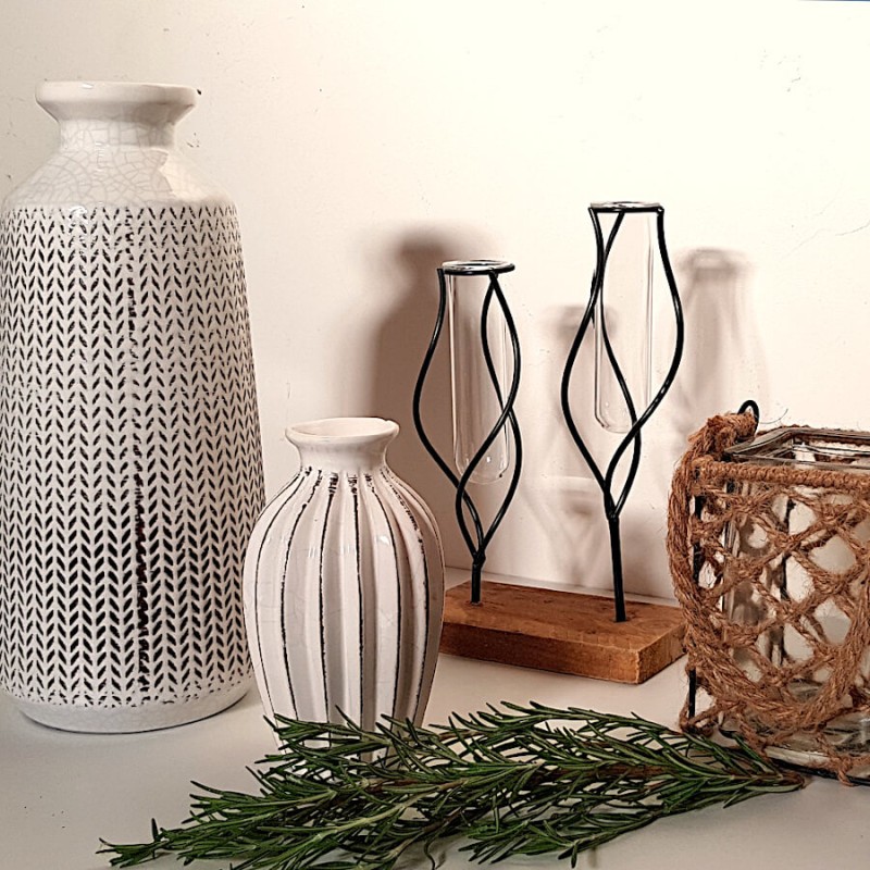 Le vase blanc associé à d'autres objets déco et bougeoirs filaires.
