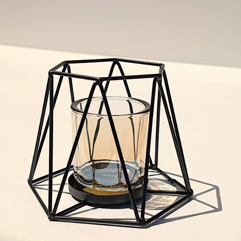Vue isolée de trois-quarts du photophore filaire noir avec son cylindre en verre ambré amovible.