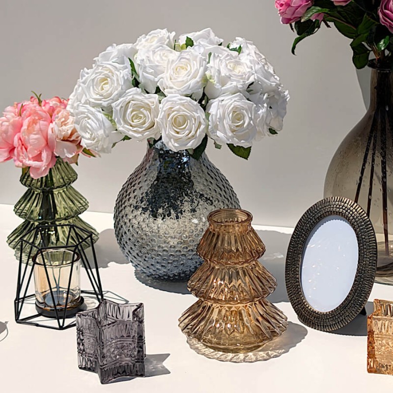 Ensemble de décoration élégant réunissant le photophore noir, un vase gris avec roses blanches et un bougeoir sapin ambré.