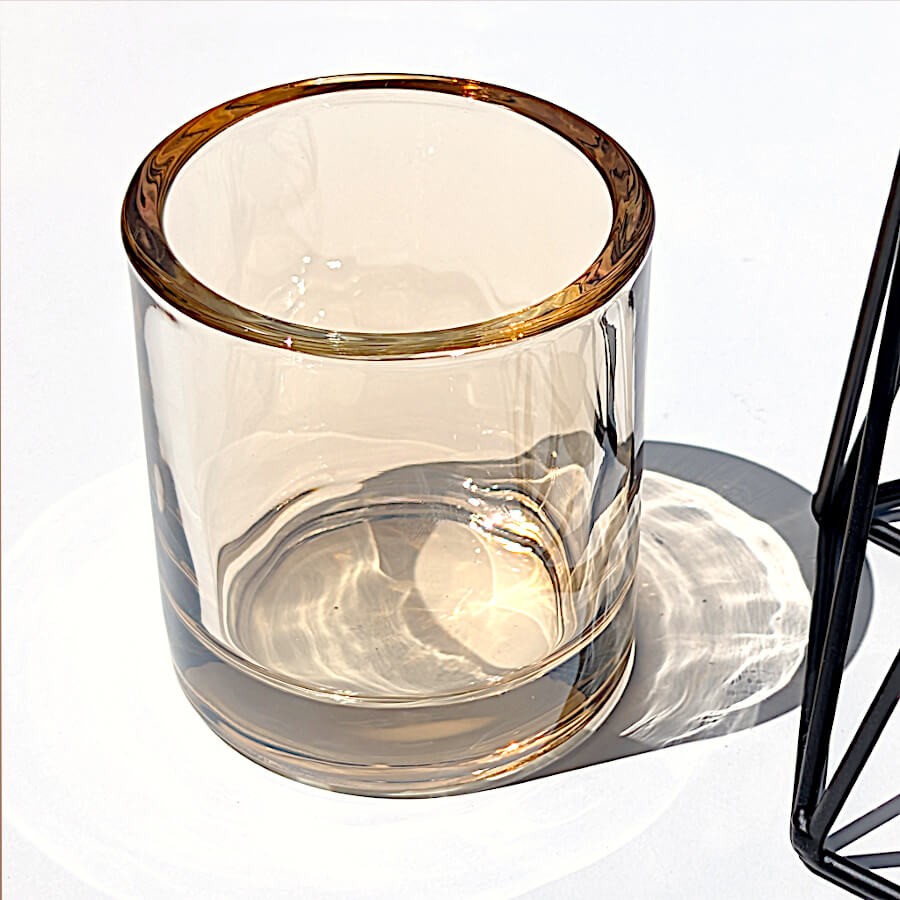 Zoom sur la qualité du verre ambré chaleureux et la transparence du gobelet porte-bougie.