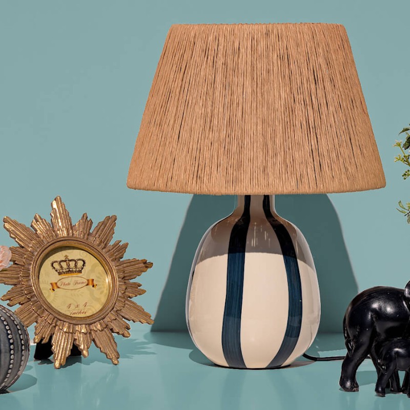 Cadre photo soleil en résine dorée posé près d'une lampe en céramique et d'une statuette éléphant de notre collection.