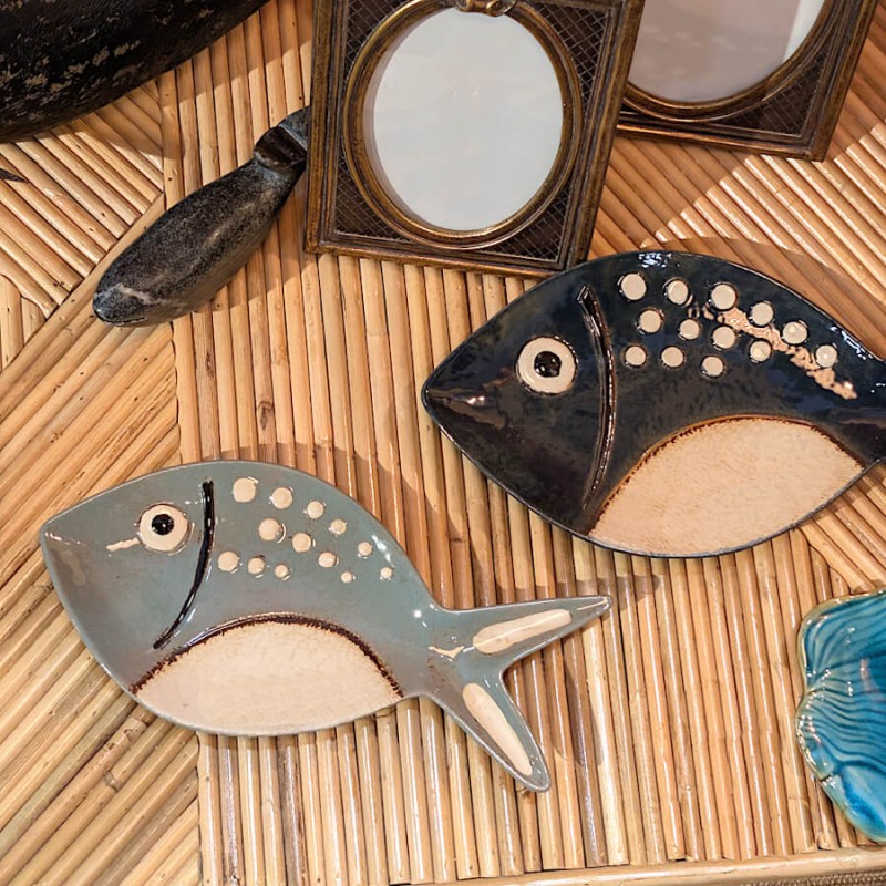 Duo de vide-poches poissons en céramique sur un plateau en rotin.