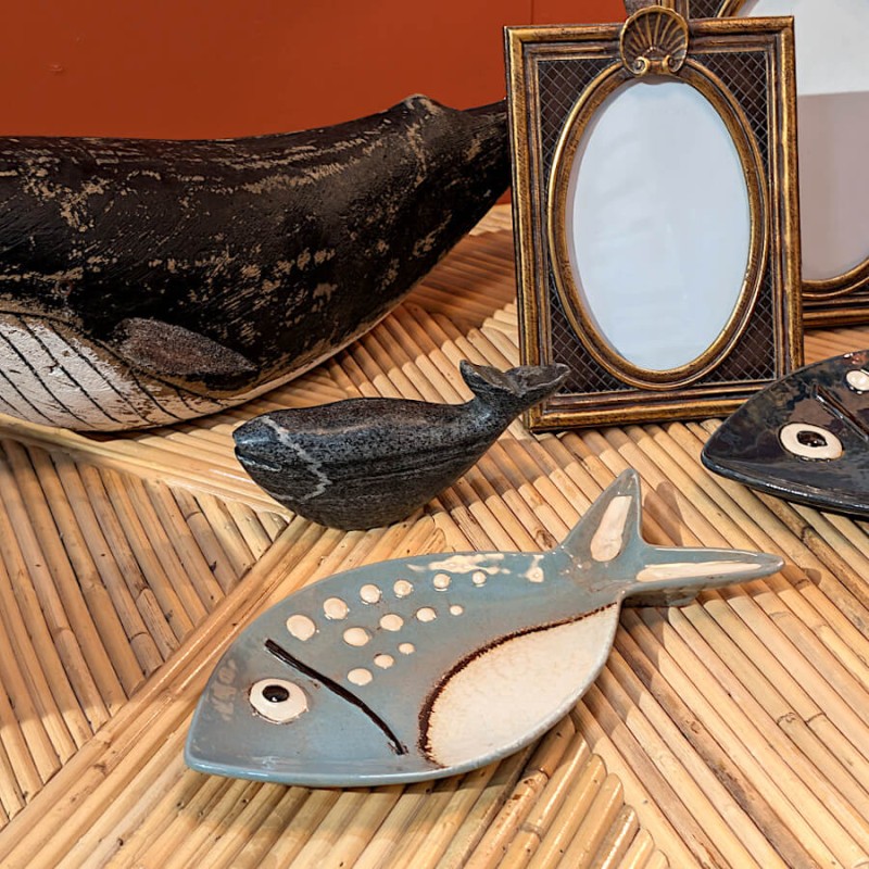 Plat poisson posé sur une table basse en rotin dans un salon esprit mer.