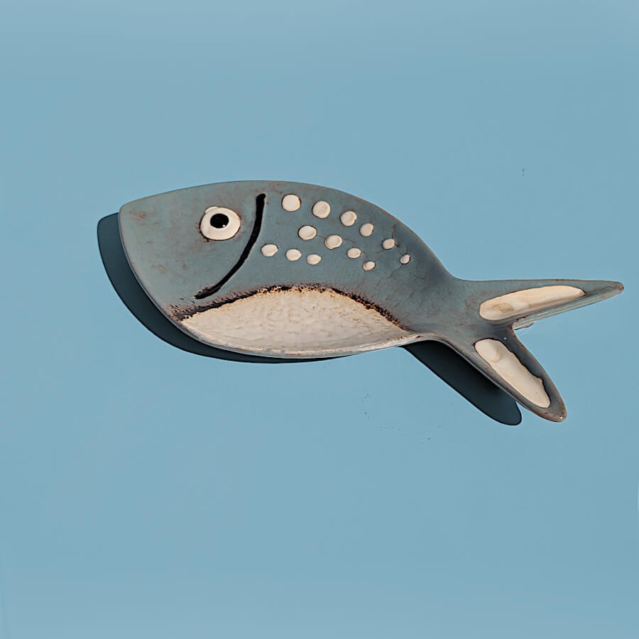 Vue isolée de profil du plat poisson en céramique bleu.