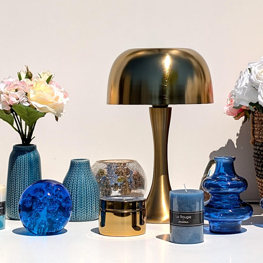 Ambiance ésotérique chic avec lampe champignon dorée, bougie bleu nuit et boîte œil.