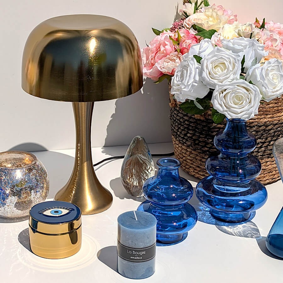 Décoration de table avec lampe en laiton doré, bougie bleu nuit et petite boîte dorée œil.