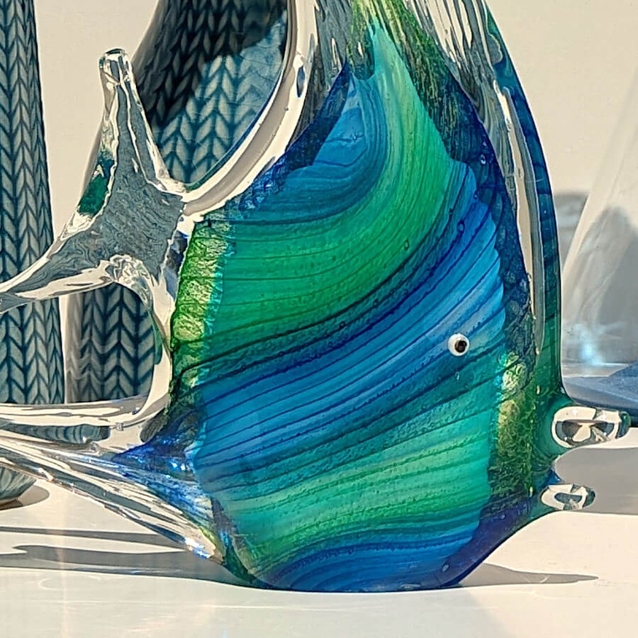 Gros plan sur les lignes bleues et turquoise travaillées dans le verre soufflé transparent.