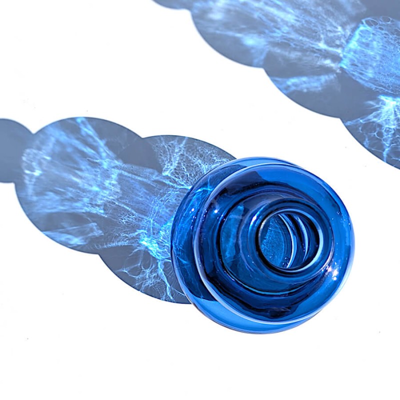 Vue du dessus plongeante révélant l'ouverture et les reflets du vase en verre bleu cobalt.