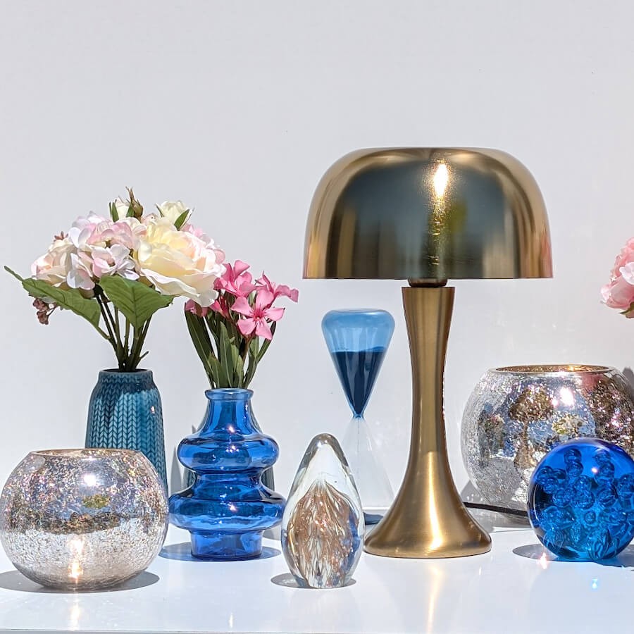 Composition déco rétro avec le vase bleu, une lampe dorée et un sulfure en verre Deco Delight.