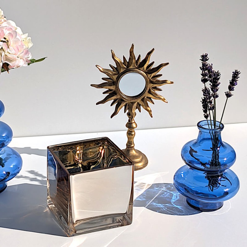 Mise en scène vintage avec le vase bleu 2 boules, le miroir soleil et un photophore carré Deco-Delight.