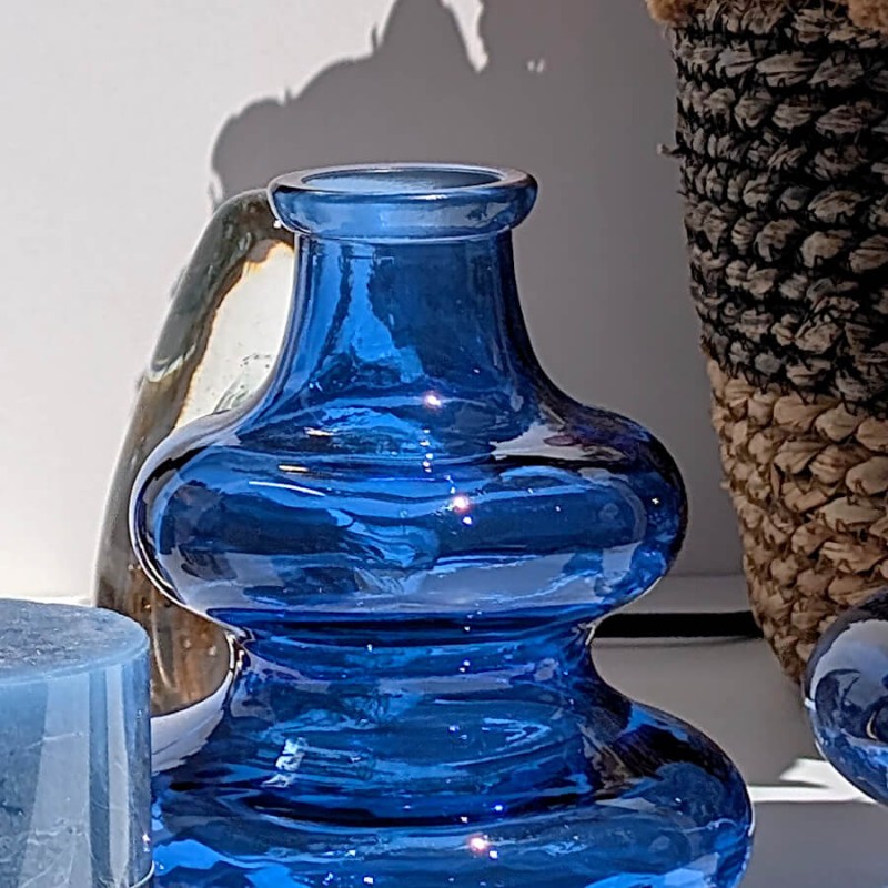 Zoom sur le col et les bulles de verre bleu attrapant la lumière du soleil.