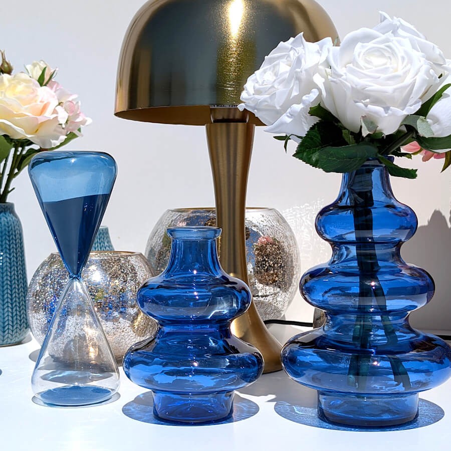Ensemble d'accessoires décoratifs de salon avec les vases bleus et la lampe champignon dorée.