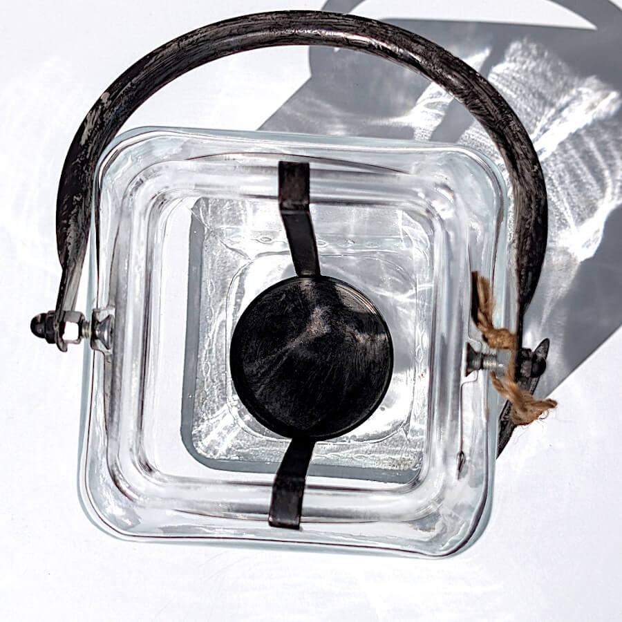 Vue du dessus de la lanterne carrée révélant le support métallique amovible pour bougie chauffe-plat.