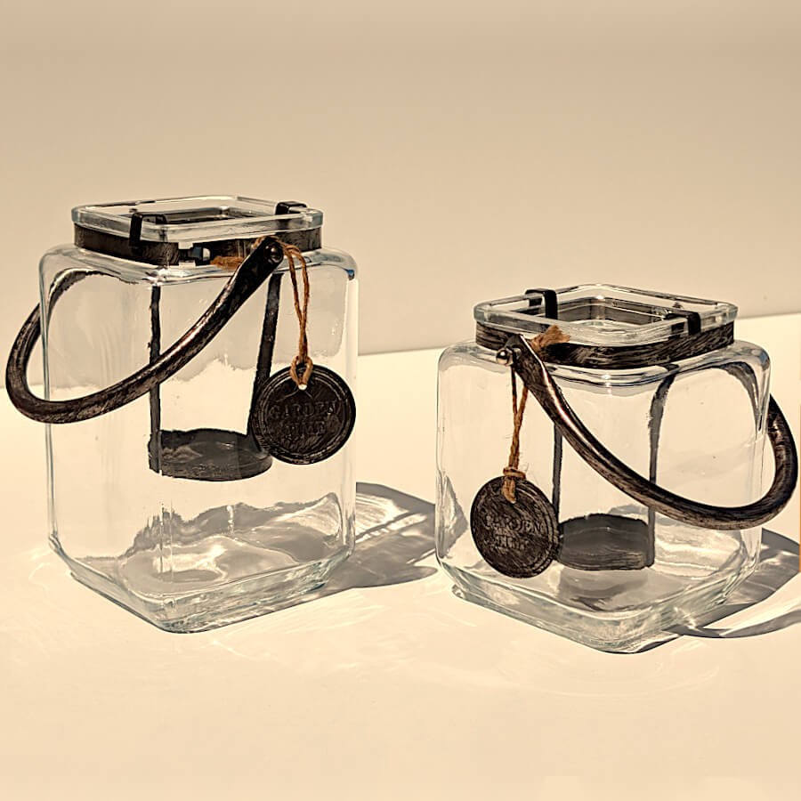 Déclinaison des deux tailles de lanternes carrées en verre et métal patiné sur fond neutre.