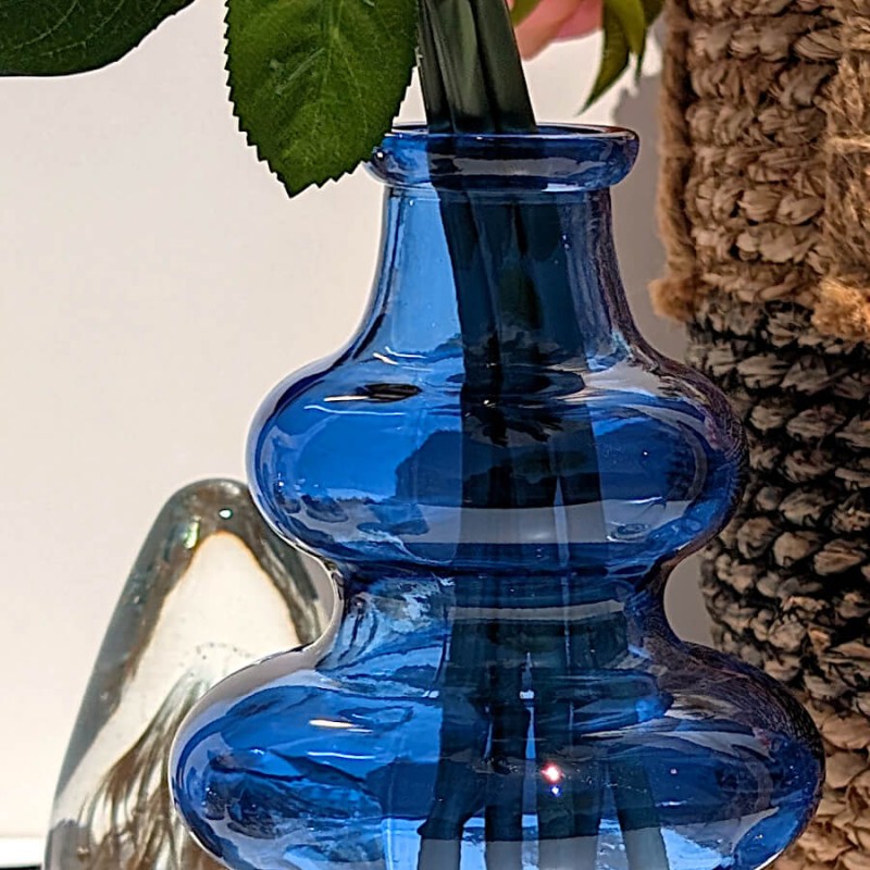 Zoom sur le col et la bulle supérieure du vase en verre bleu azur sous la lumière.