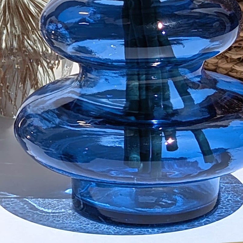 Gros plan sur la base et les premières bulles du vase en verre bleu cobalt.