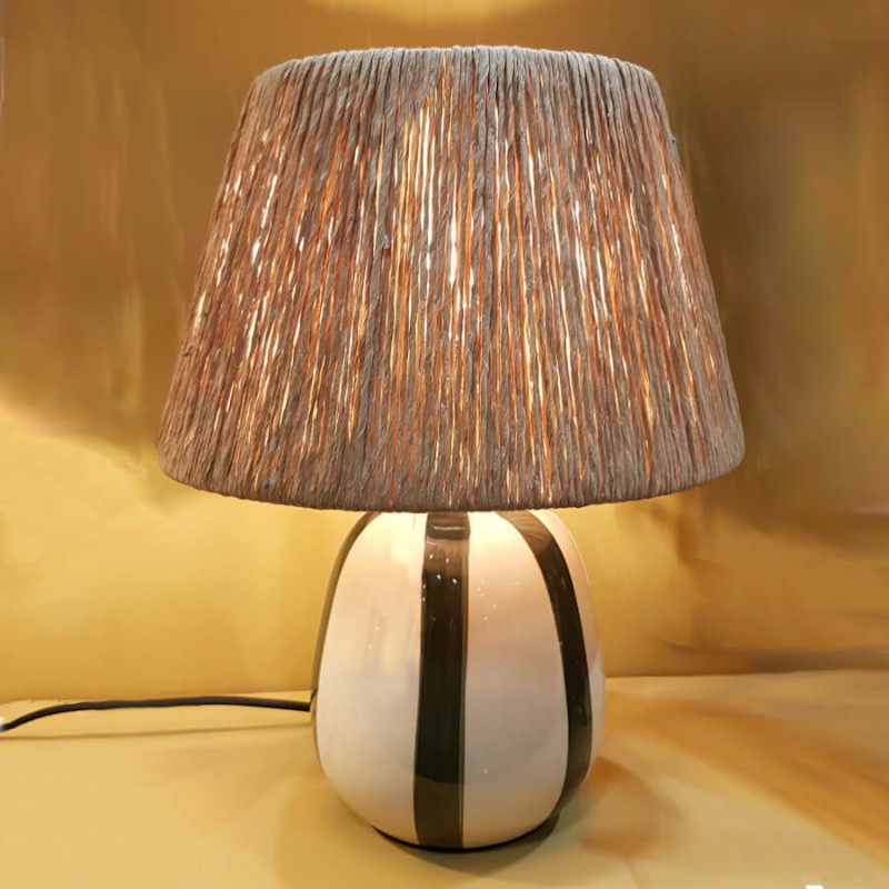 Lampe à poser Riviera allumée diffusant un éclairage d'ambiance chaleureux.