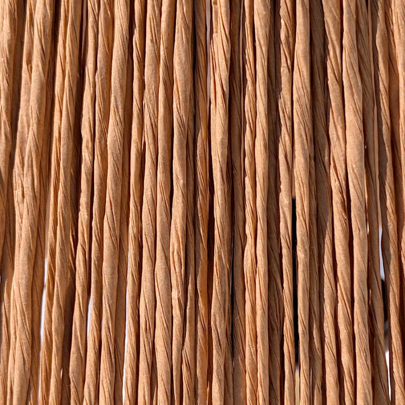 Gros plan sur la texture tressée des fibres naturelles de l'abat-jour en rafia.