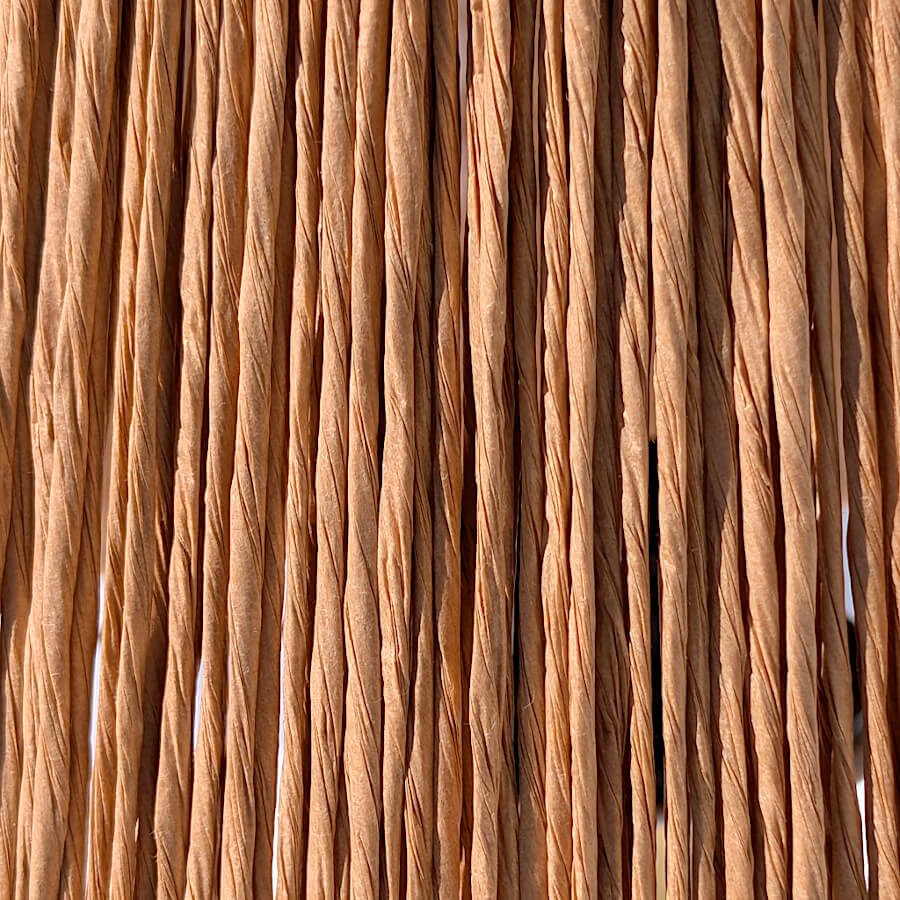 Gros plan sur la texture tressée des fibres naturelles de l'abat-jour en rafia.
