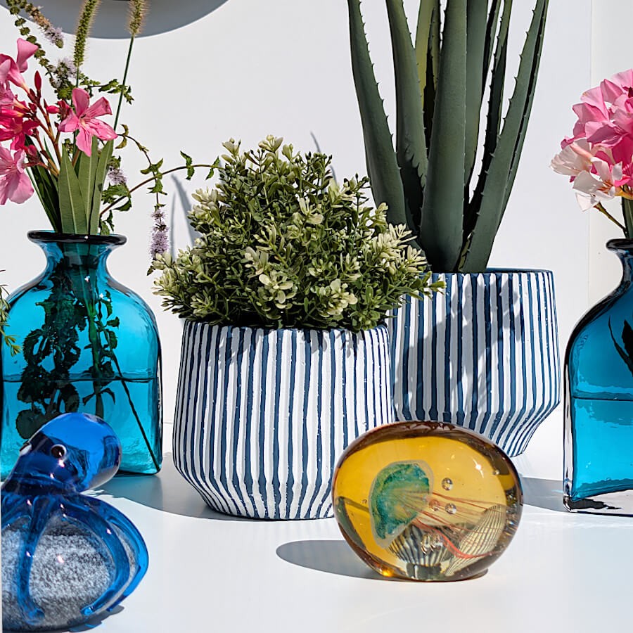 Composition estivale fleurie avec cache-pot à rayures, vases bleus, pivoines roses et sulfure méduse.