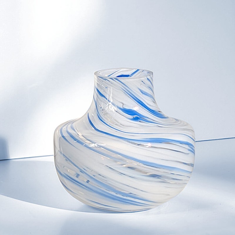 Vase en verre opalin marbré bleu et blanc isolé de face mettant en valeur sa forme évasée.