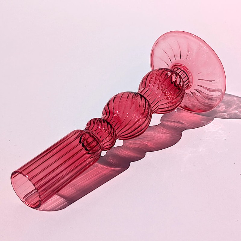 Gros plan sur le détail des bulles en verre rose teinté et de la base striée.