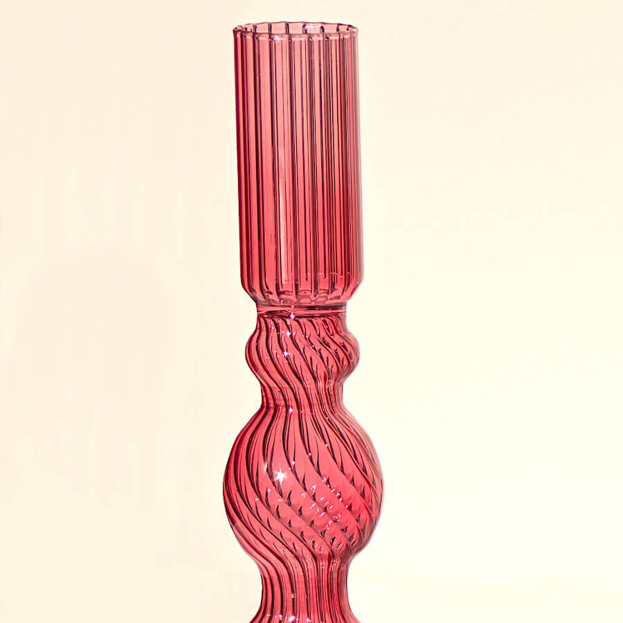 Zoom sur la partie supérieure striée torsadée du bougeoir en verre rose.