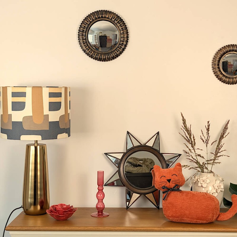 Mise en scène d'angle avec lampe rétro années 70, miroir sorcière et bougeoir rose framboise.